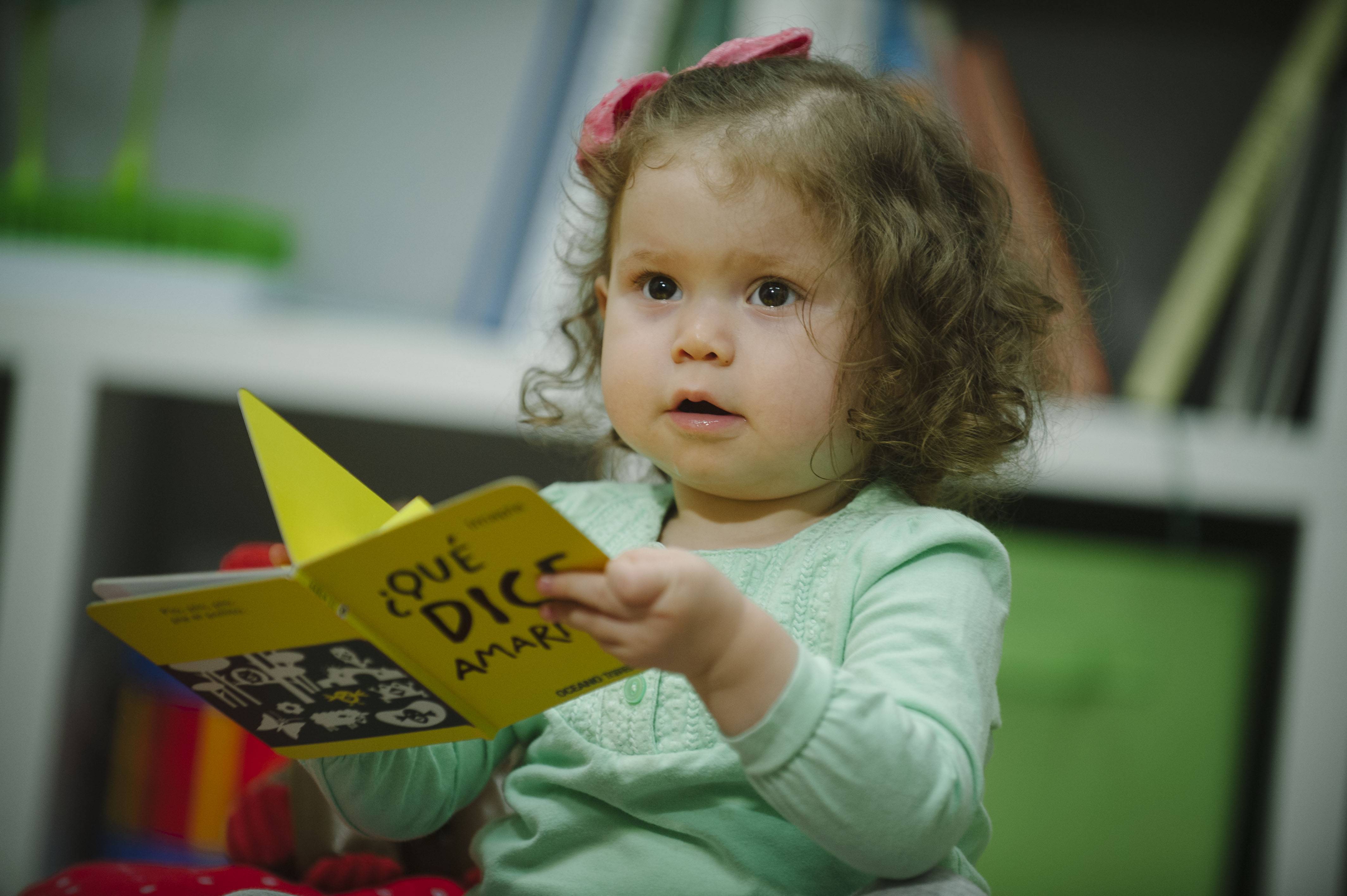 Baby girl holding a children's book