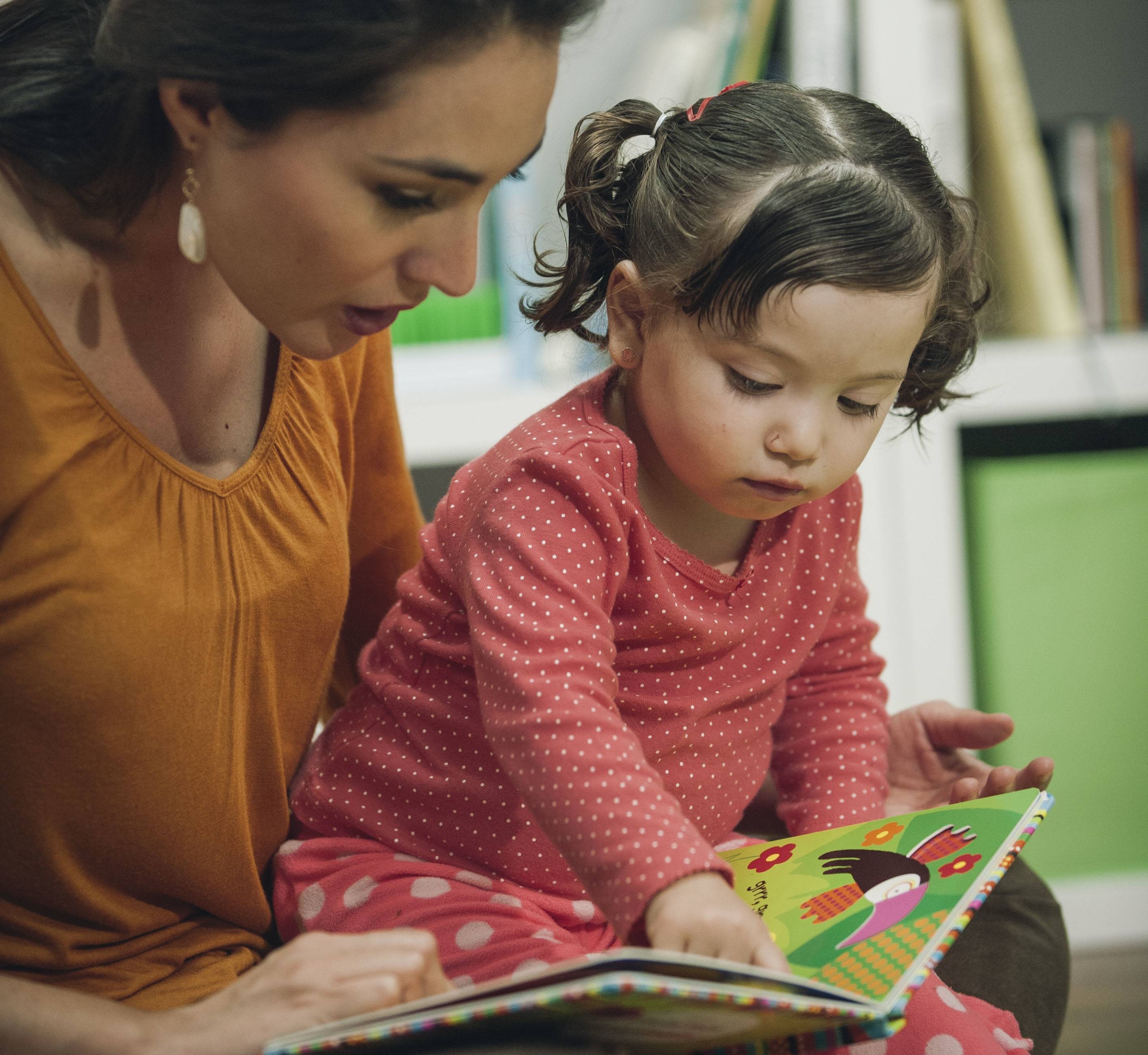mother and little girl reading a children's book