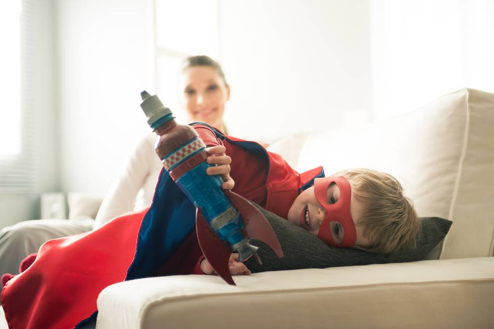 little boy dressed as a superhero with mom who boosts her kid's creativity