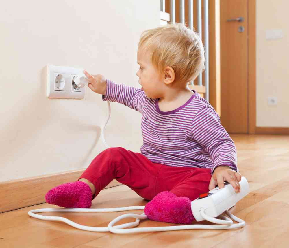 baby girl playing with electrical socket