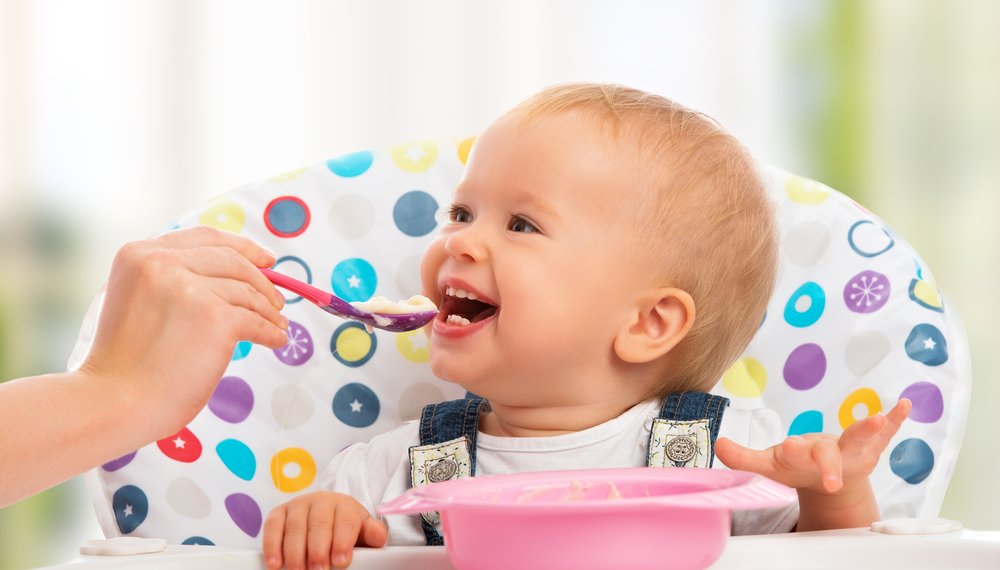 baby laughing while eating solid food