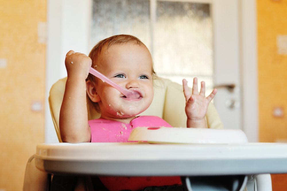 baby girl eating with a spoon