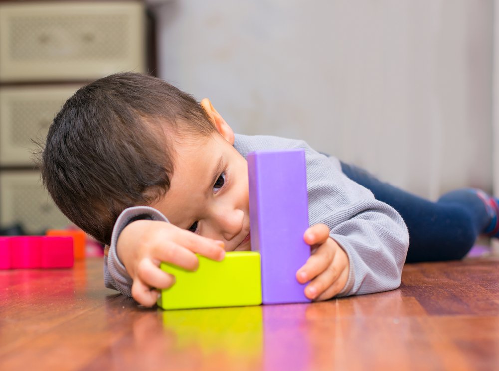 little boy playing with wooden blocks