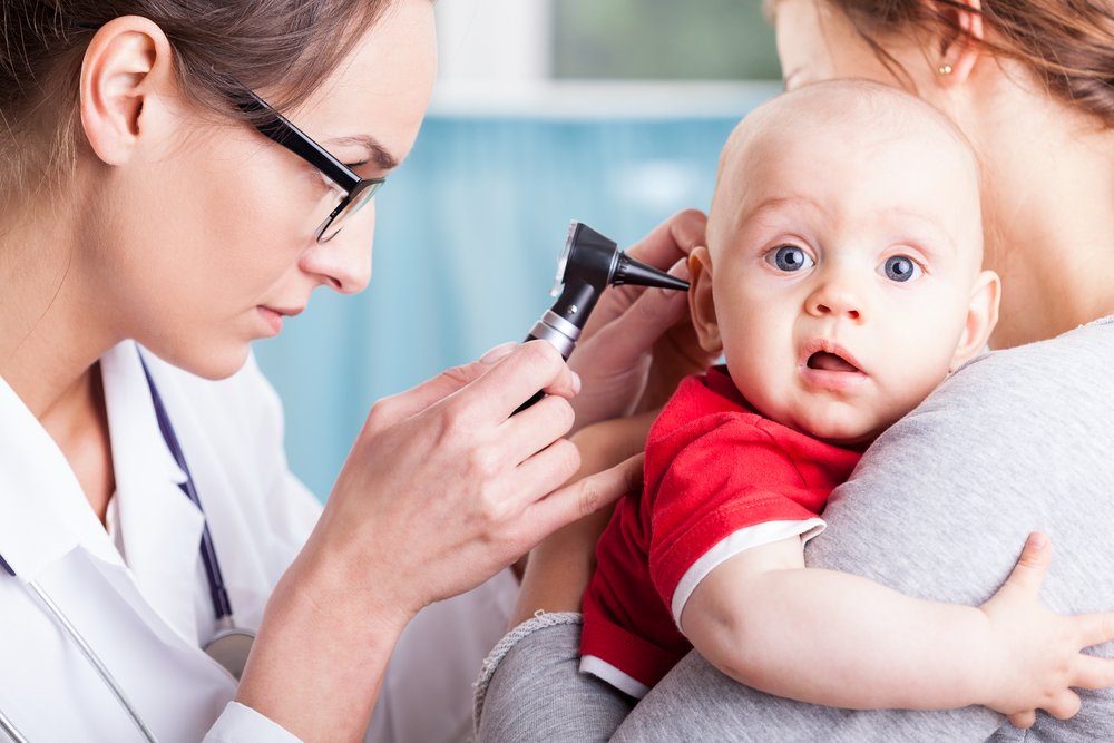 pediatrician checking a baby's ear