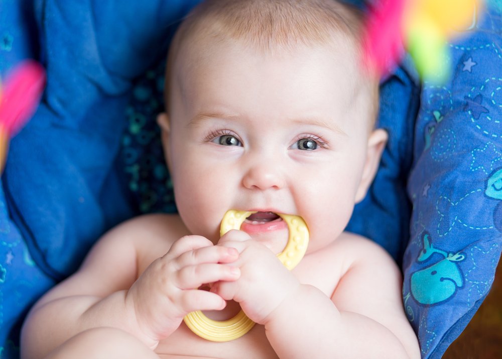 baby teething and chewing a toy