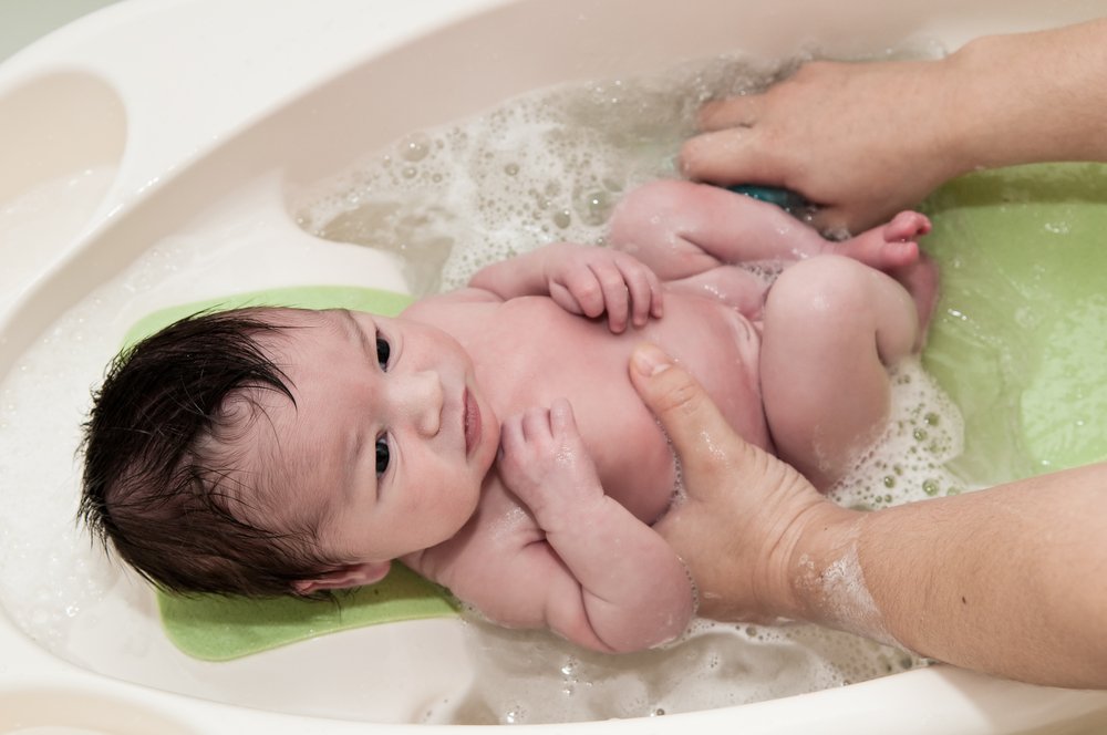 adult bathing a baby