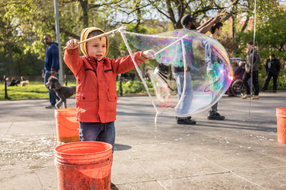 little boy making giant bubbles