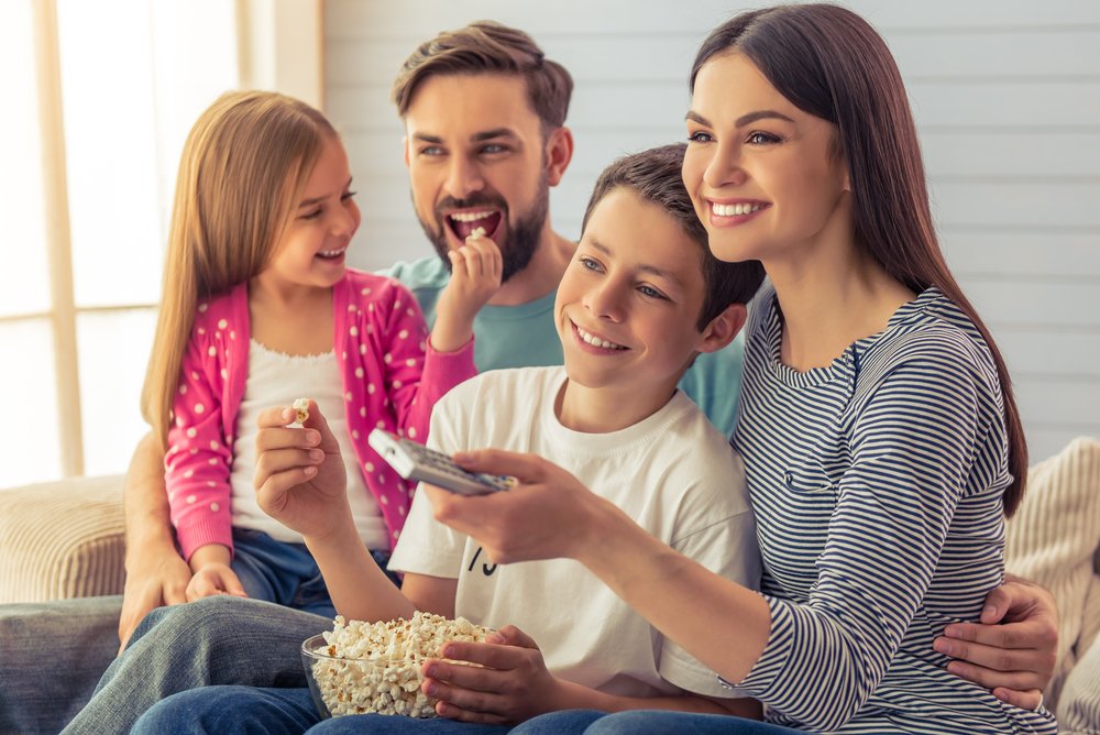 family of four watching TV