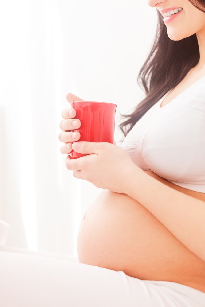 pregnant woman holding a glass of juice