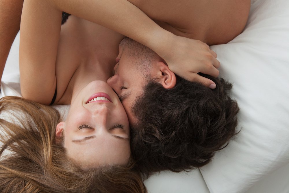 couple kissing on a bed