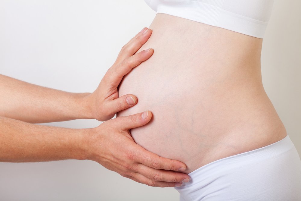 partner touching pregnant woman's belly