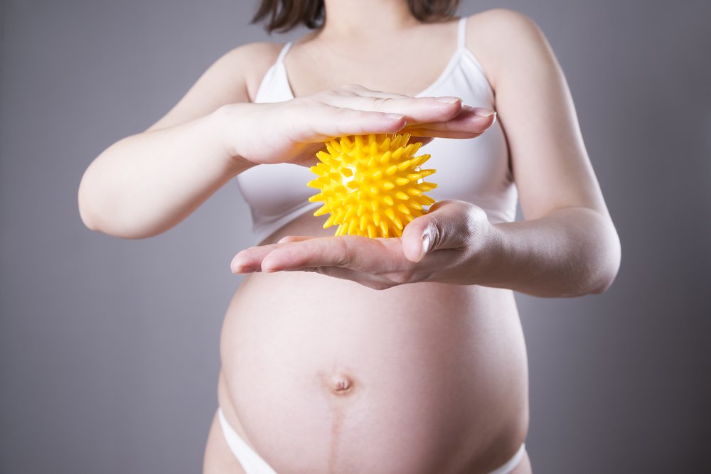 pregnant woman holding a textured ball