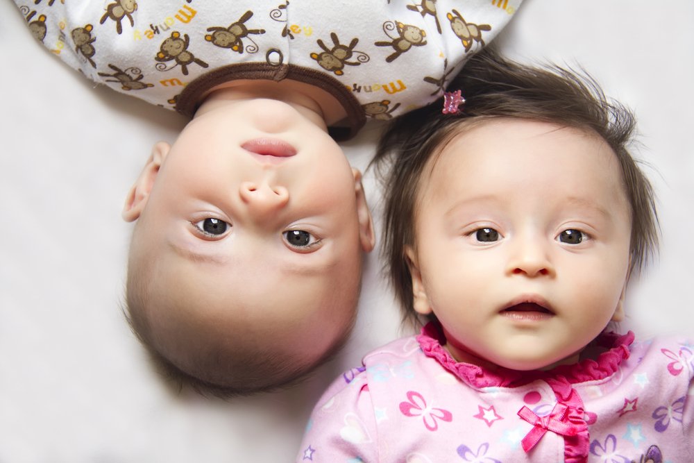 baby boy and baby girl staring at the camera