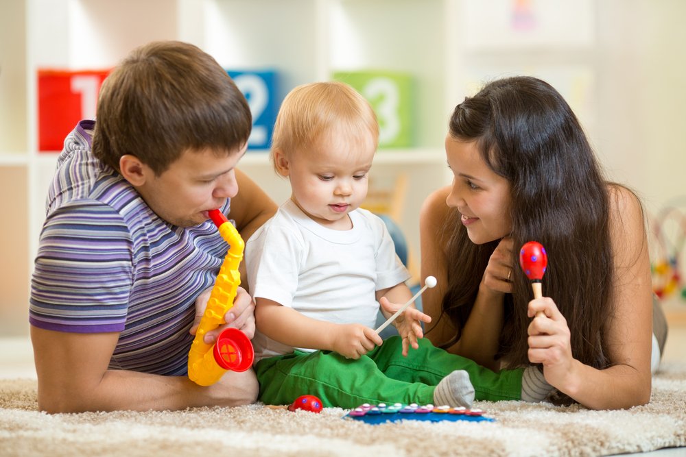 parents and baby playing with toy instruments