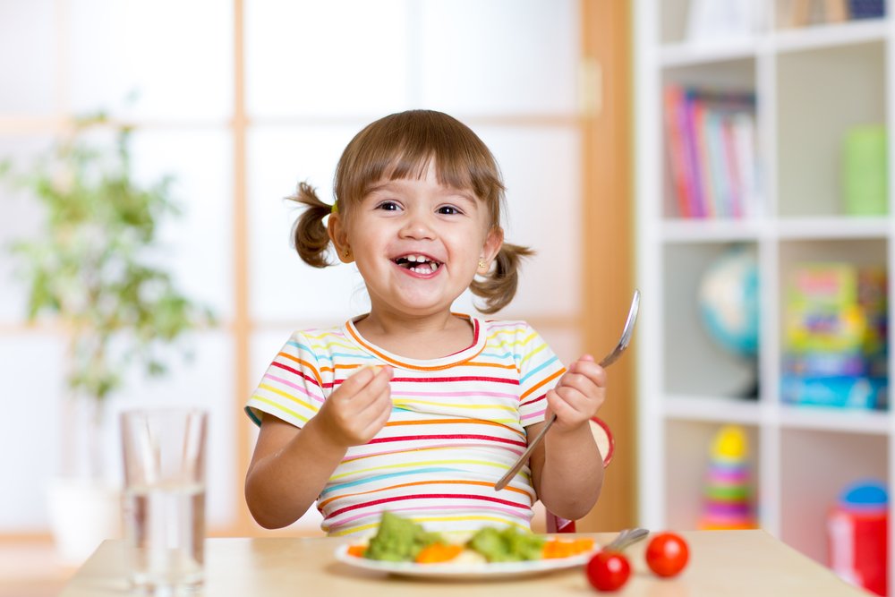 happy little girl eating fruit