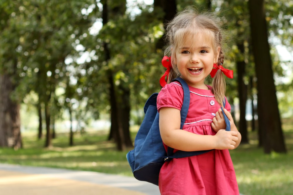 happy little girl wearing a backpack