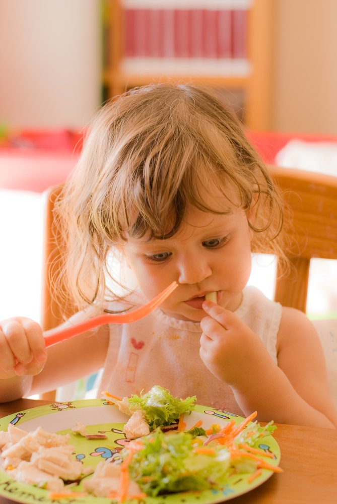 little girl eating with a fork