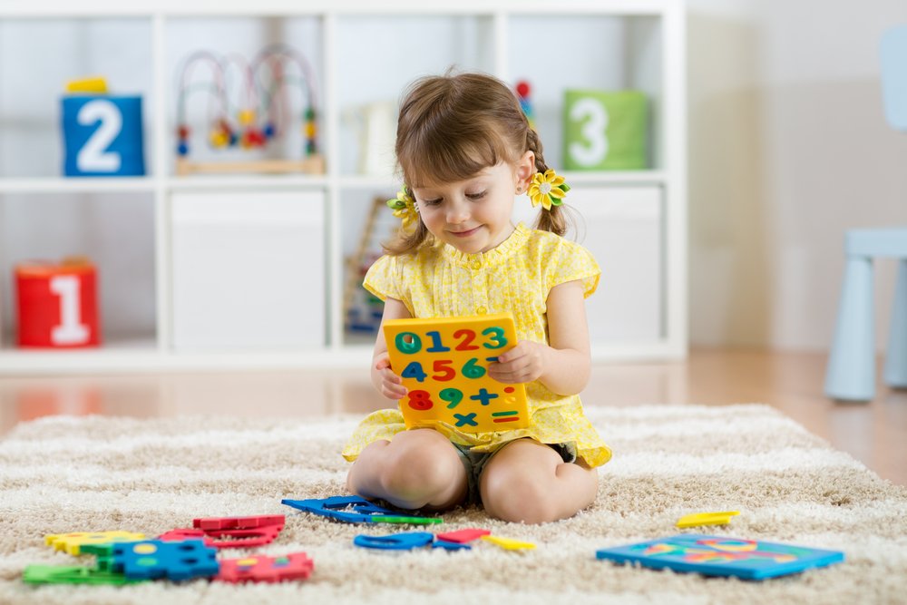 little girl playing with number puzzle