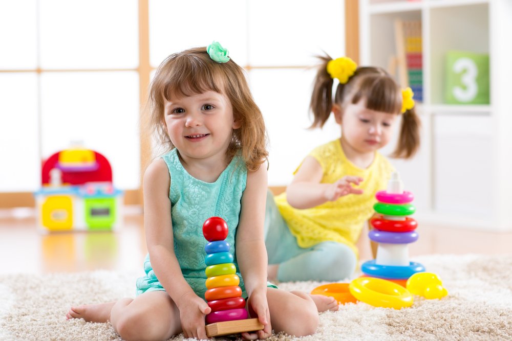 two little girls playing with colorful toys
