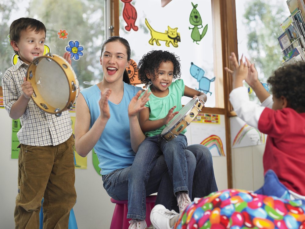children and woman playing with musical instruments
