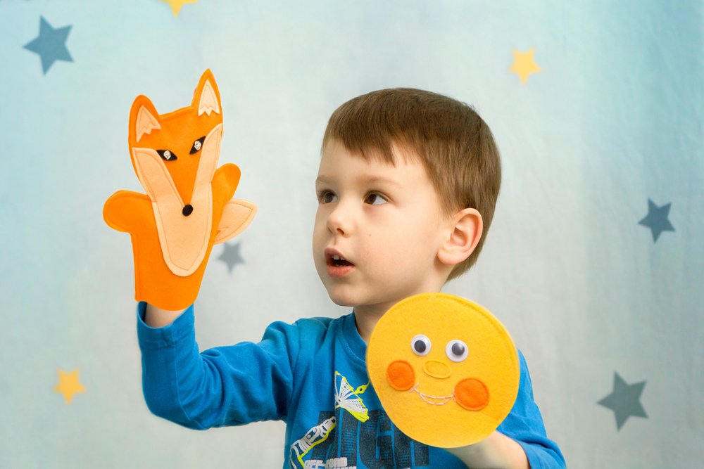 little boy playing with puppets