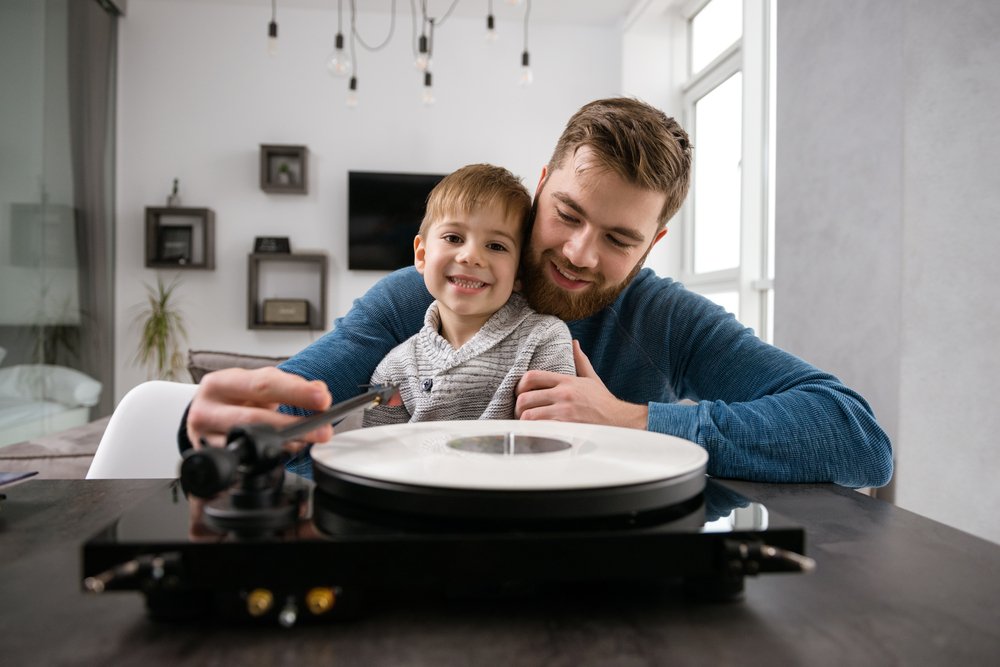 little boy and father listening to a vinyl record
