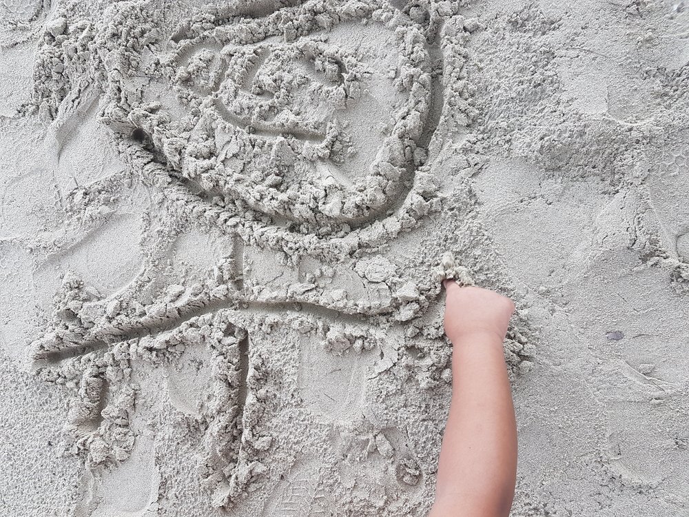 toddler drawing on the sand