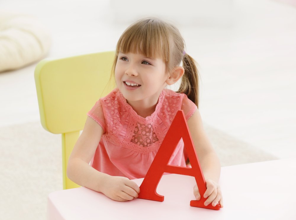 little girl holding the letter A