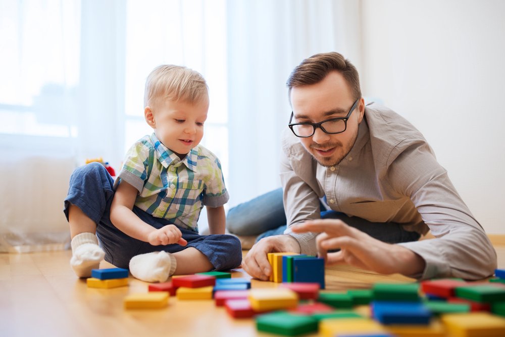 little boy playing with blocks with his father