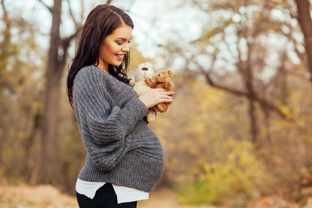 pregnant woman with mini teddy bear