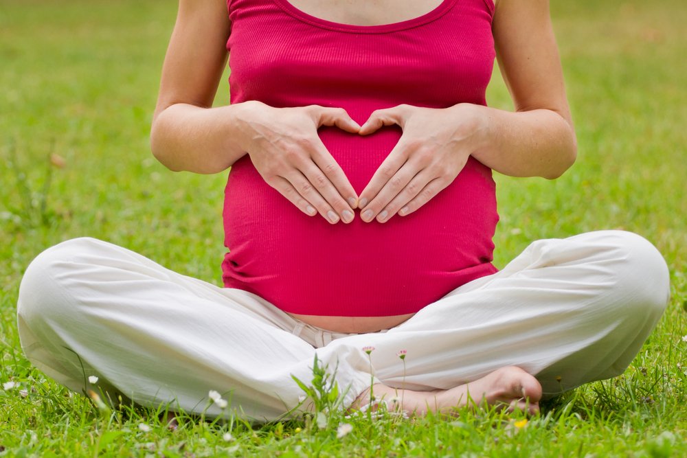 pregnant woman with hands shaped as a heart