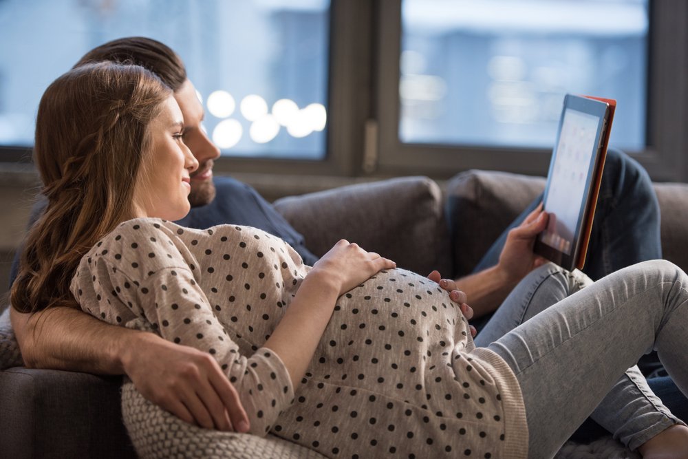 pregnant woman and partner watching a tablet