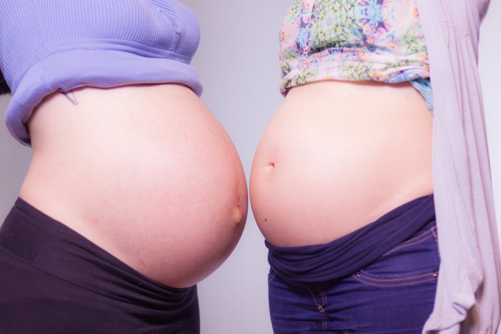two pregnant women's bellies