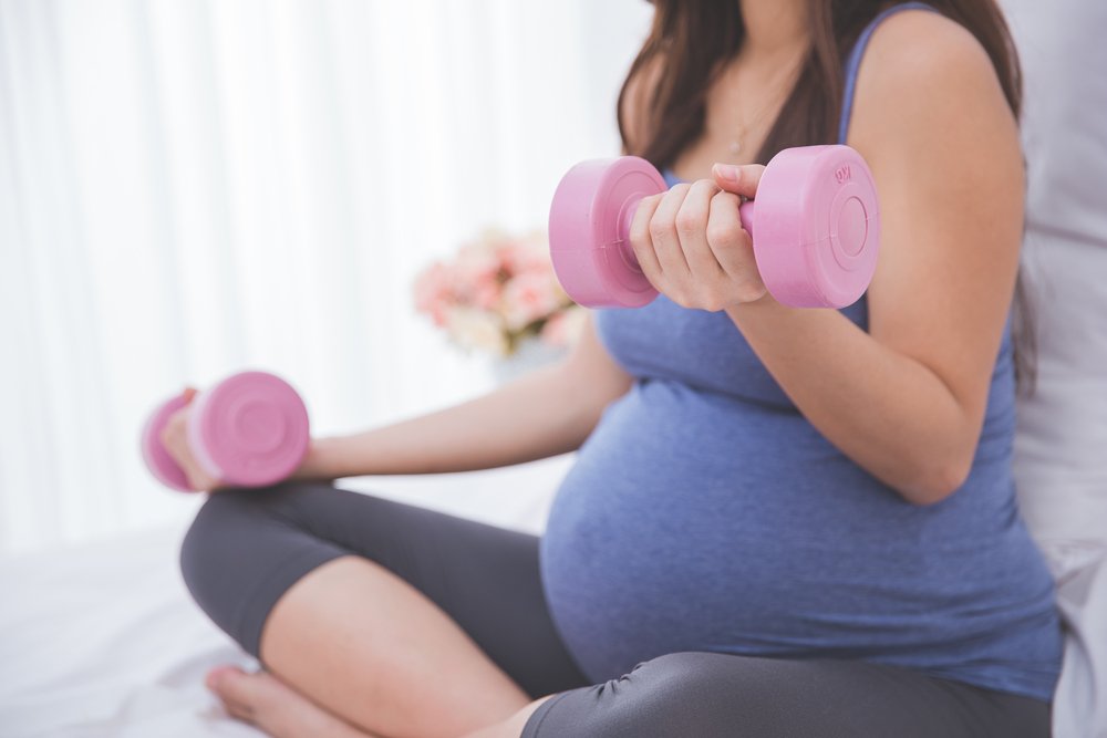 pregnant woman exercising arms with weights