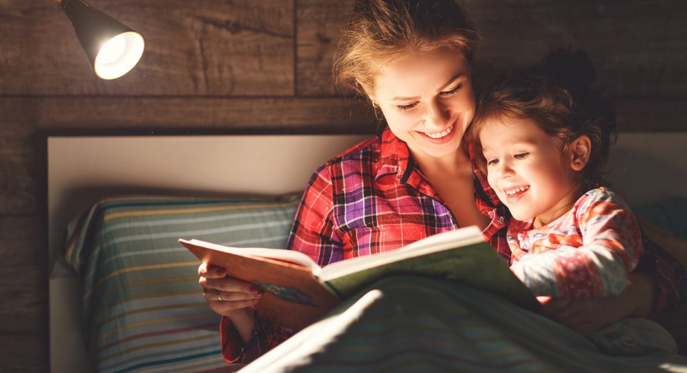 little girl reading with mom