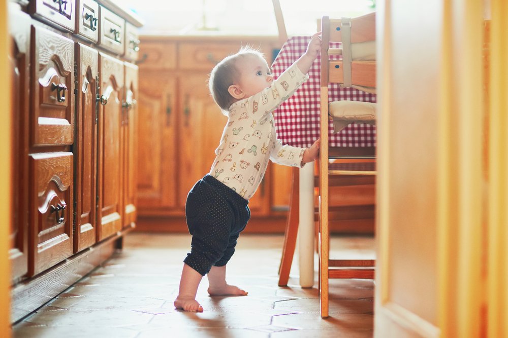 baby standing up using a chair as support