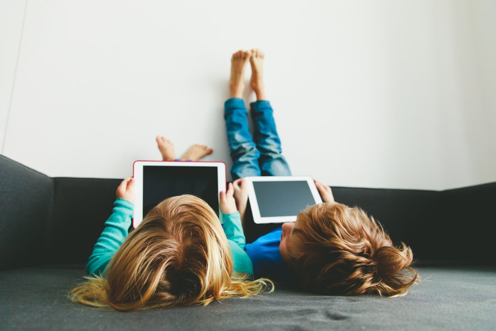 siblings watching videos on tablets