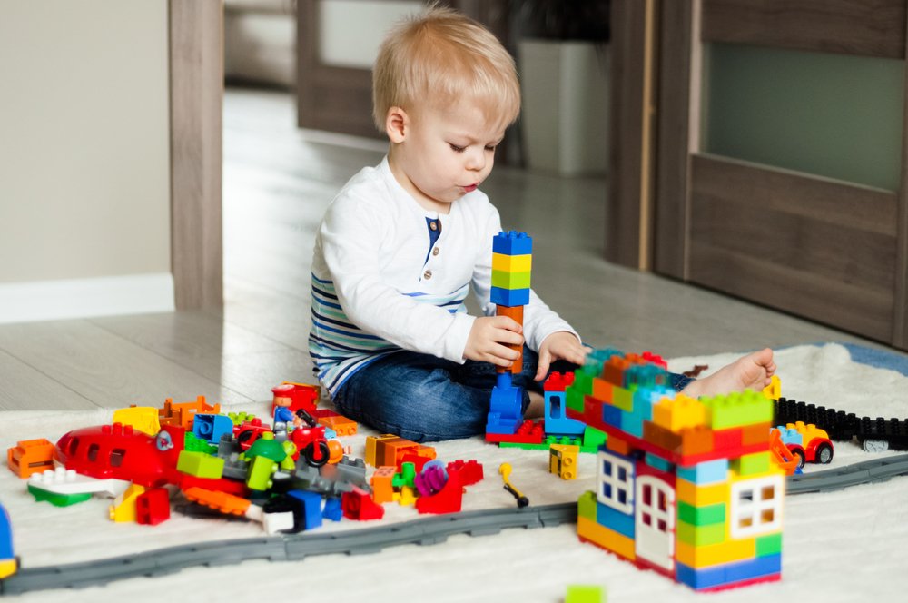 little boy practicing object manipulation with blocks