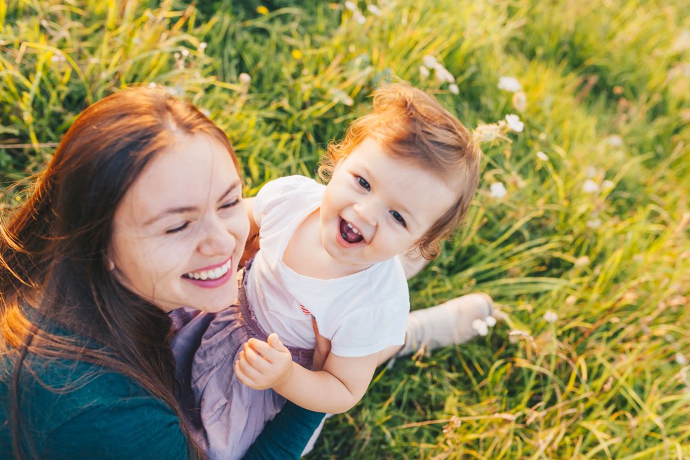 baby and mom smiling outdoors