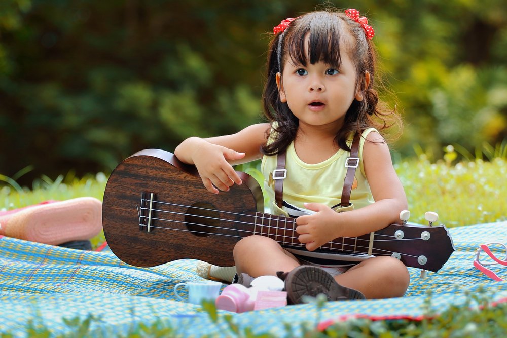 little girl holding a toy guitar
