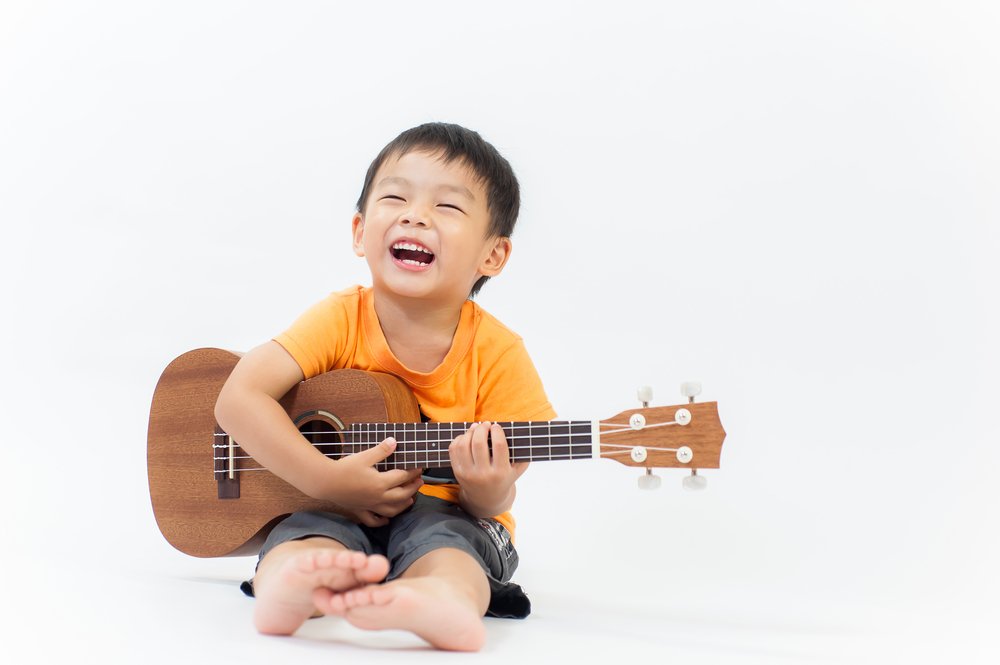 little boy holding guitar