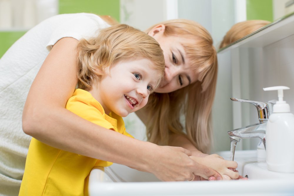mom teaching her son how to wash his hands