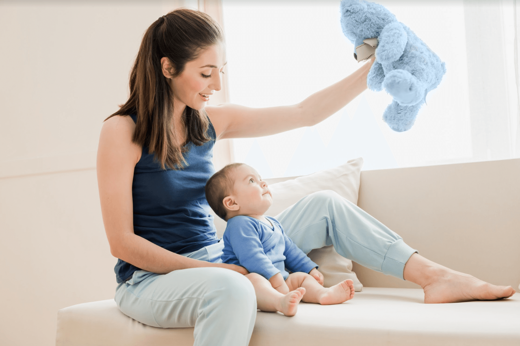 mom showing a blue teddy bear to her baby