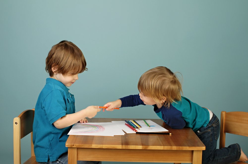 Toddlers sharing crayons