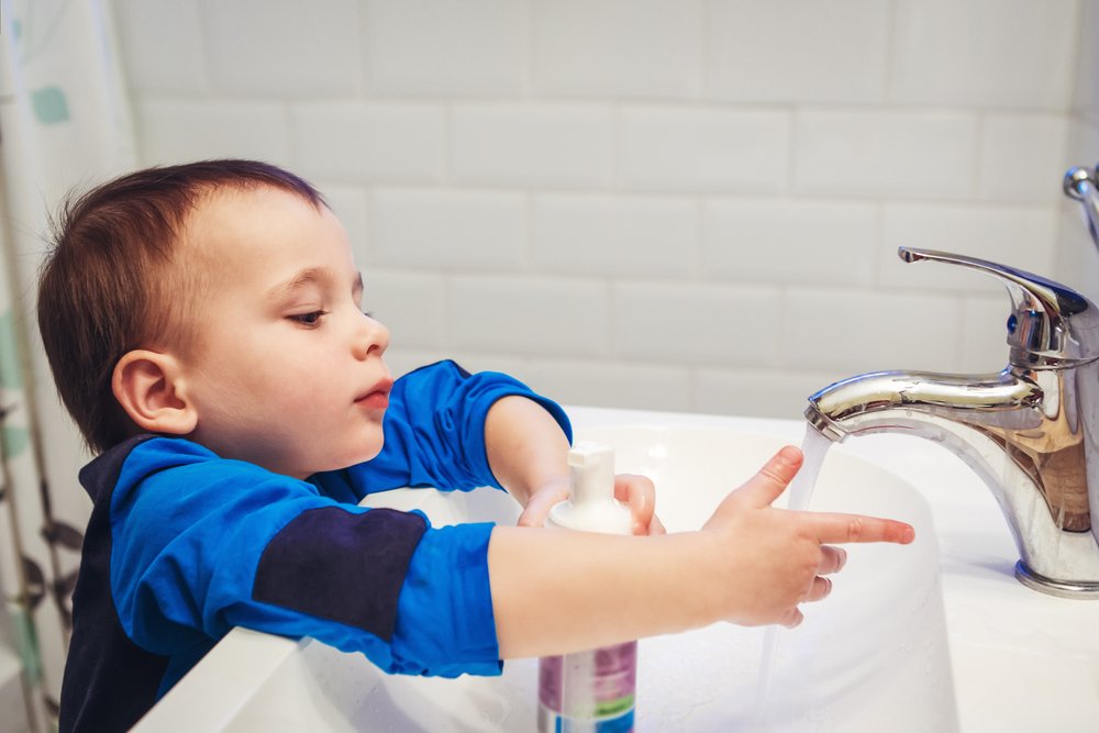 little boy washing his hands