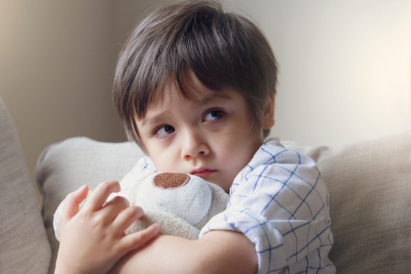 scared little boy hugging a stuffed animal