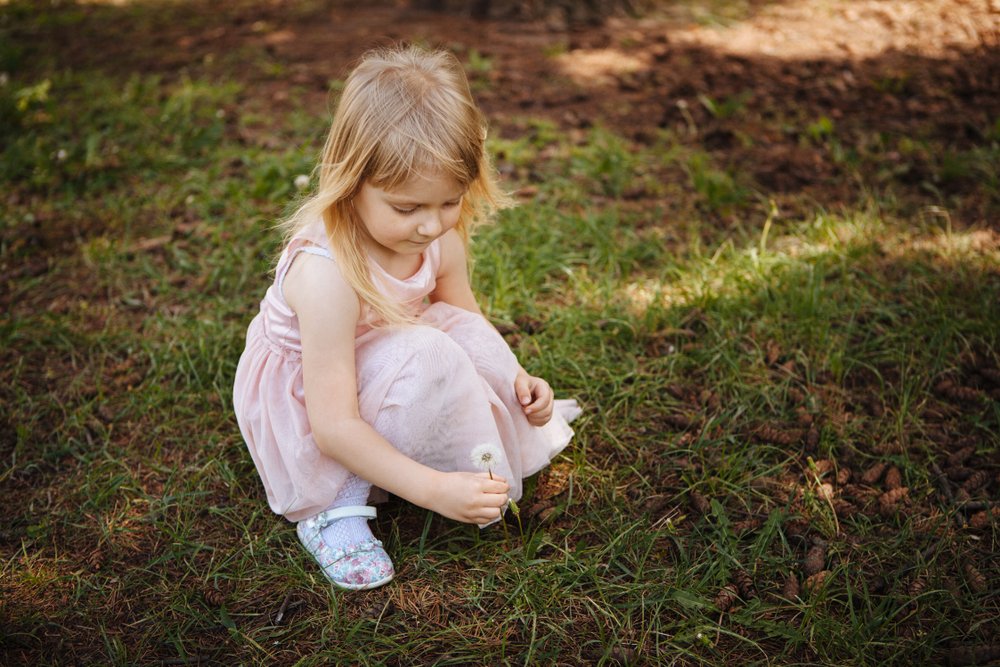 little girl picking a flower