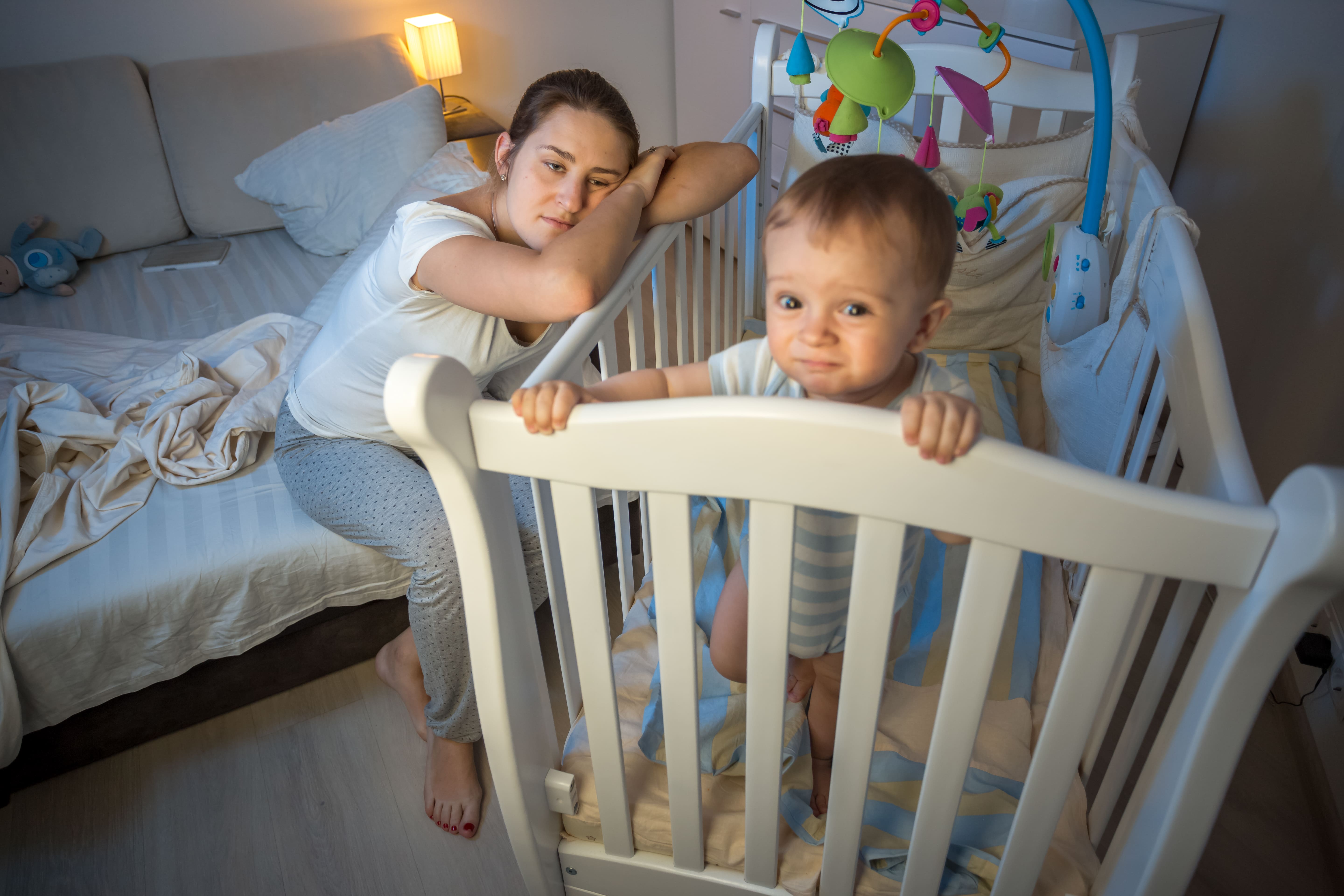 baby in crib and exhausted mom