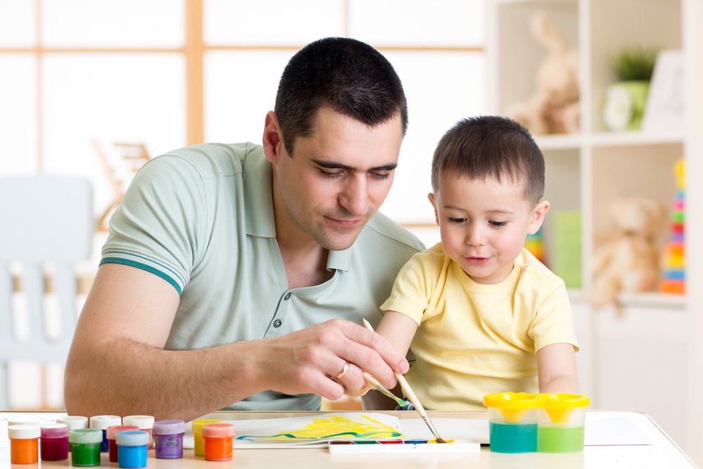 father and son painting together at home