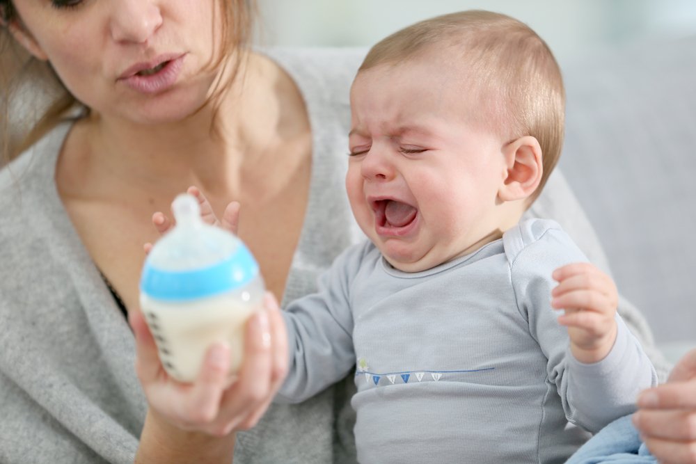 crying baby rejecting bottle